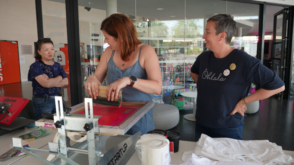 Tatiana du FabLab de Bornybuzz Numérique prépare un Totebag "Voilà l'été" à Céline de Cassis | Photo BORNYBUZZ / Aurélien ZANN