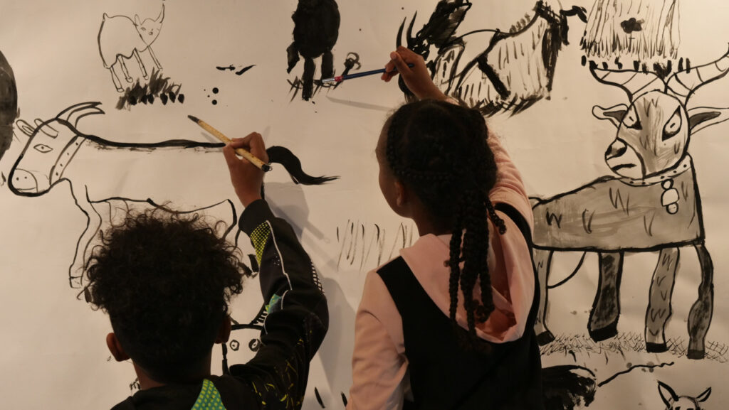 Deux enfants du P'tit Lab peignent une fresque à l'encre de chine pour l'exposition Portraits sonores de l’association Bouche à Oreille (BAO). Le 6 juillet au Cloître des Récollets à Metz | Photo et graphisme BORNYBUZZ / Aurélien ZANN